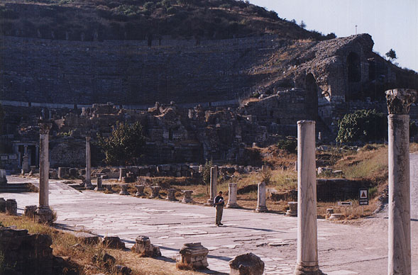 Andy looks at his map along a columned road near a giant ampitheatre